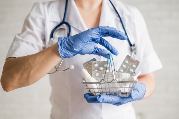 A faceless female doctor holds a mini basket with medicines