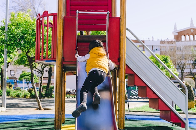 写真 顔のない女の子はスライドを登ろうとする