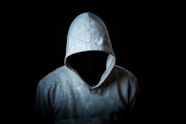 Faceless incognito man wear hood on dark background isolated b