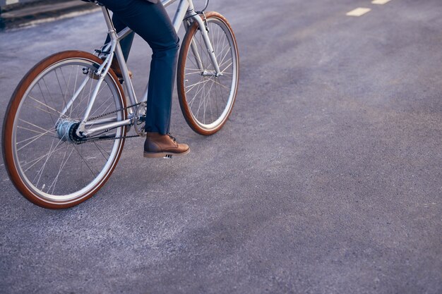 アスファルト道路で自転車に乗る顔のない男