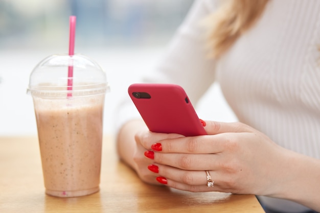 Faceless woman holds modern cell phone in hands