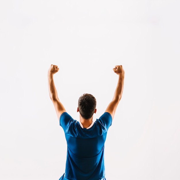 Faceless young football player celebrating victory