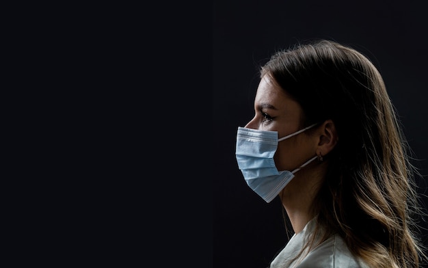 Faces of people in protective masks from coronavirus. Beautiful quarantined couple. Couple wearing a protective face mask, pandemic and feelings concept. Lifestyle COVID-19.