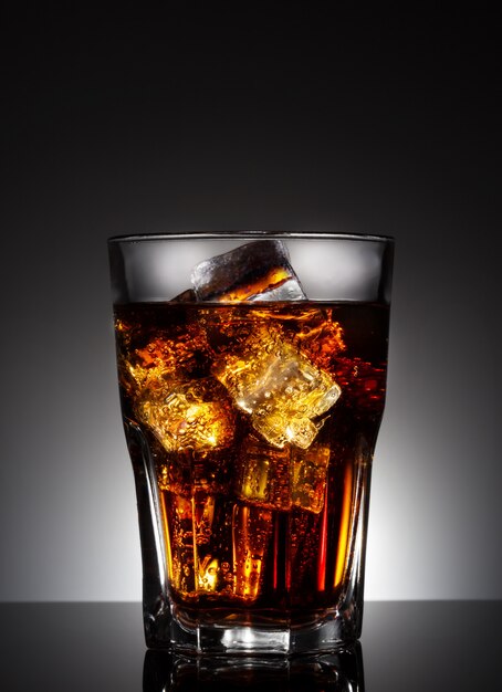 Faceted glass of cola with ice