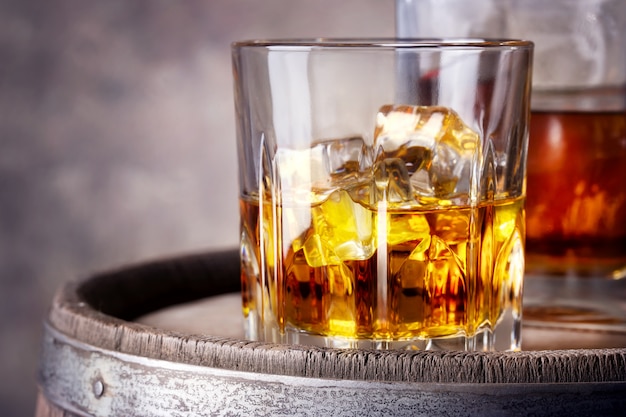 Faceted glass of whiskey with ice