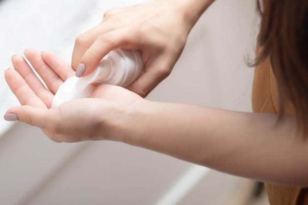 Facial cleansing women's hands with foam for washing in a tube