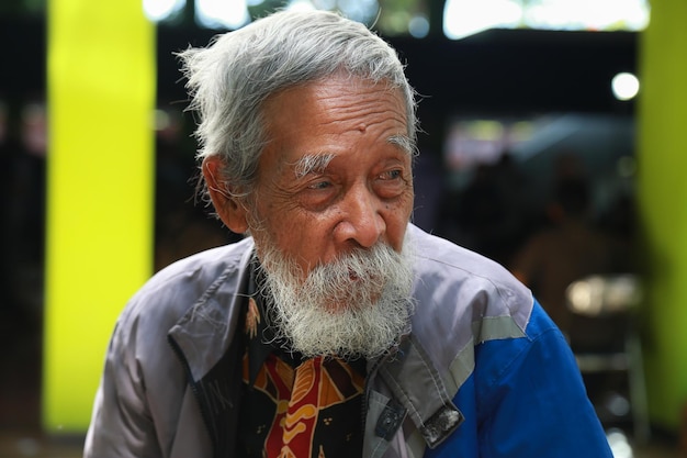 Facial expression of an old tired man with grey hair, moustache and bear