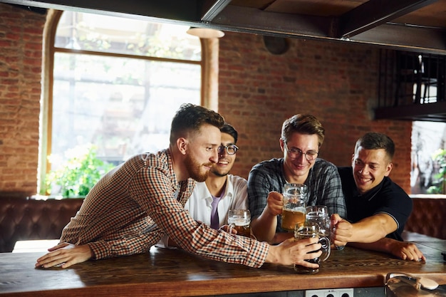 Photo facial expression people in casual clothes sitting in the pub