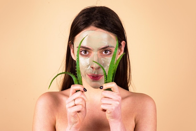 Facial girl with aloe vera cream beauty girl with green facial masks on over yellow background isola...