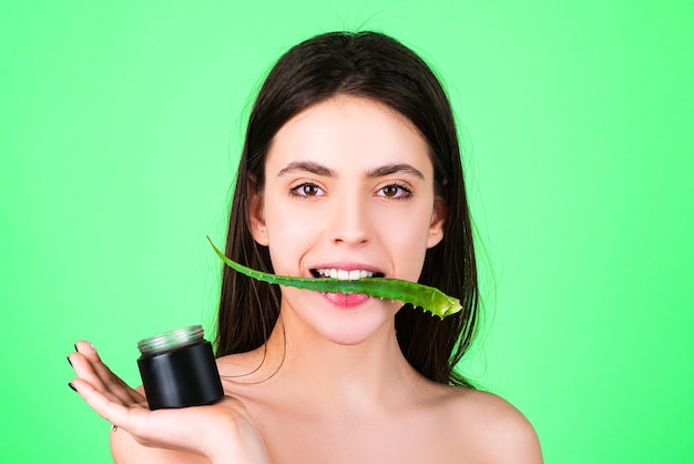 Facial green mask for beauty woman. Beautiful woman holding facial care with aloe vera. Beautician is making facial mask on woman face. Facial procedure with aloe vera.