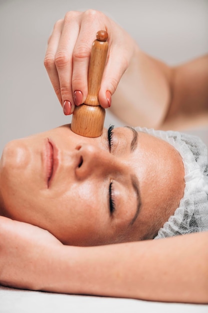 Facial Madero-therapiemassage met houten vacuümmassager