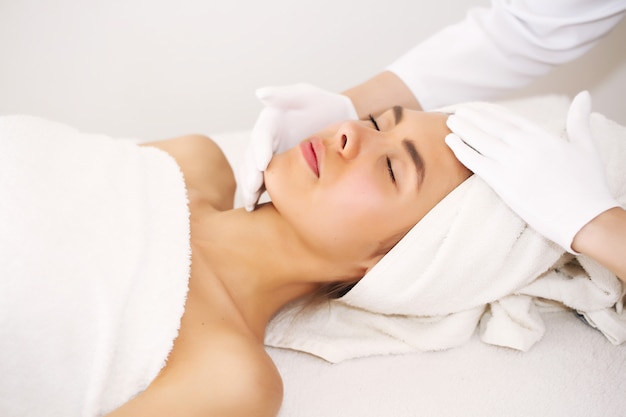 Facial massage. Beautiful young woman relaxing with hand massage in beauty spa.