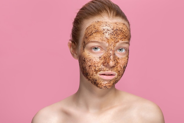 Foto la pelle del viso macchia la maschera di fondi di caffè sul viso di una giovane e bella donna