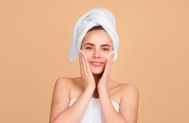 facial treatment cosmetology beauty and spa girl apply skincare cream on face woman wrap towel on