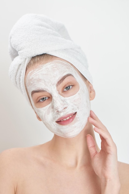 Facials. A girl with a towel on his head and a mask on her face