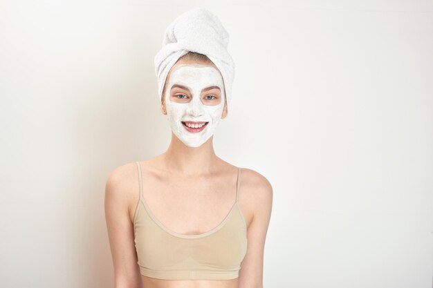 Facials. A girl with a towel on his head and a mask on her face