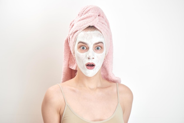 Facials. A girl with a towel on his head and a mask on her face