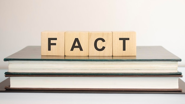 FACT word written on wooden blocks on a brown background