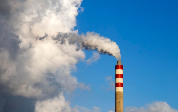 Foto fumo di camino di fabbrica con cielo blu e nuvole