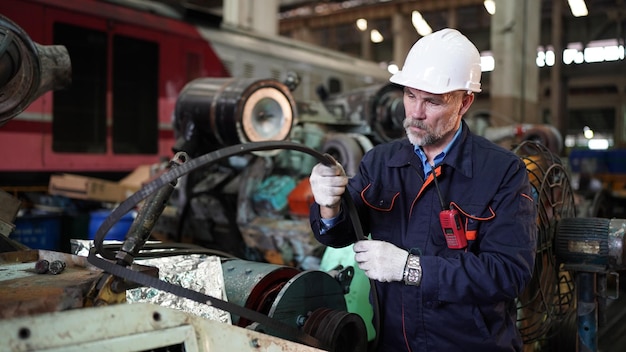 Factory engineer or foreman worker maintaining check equipment parts in factory