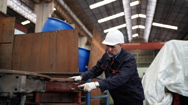 Factory engineer or foreman worker maintaining check equipment\
parts in factory