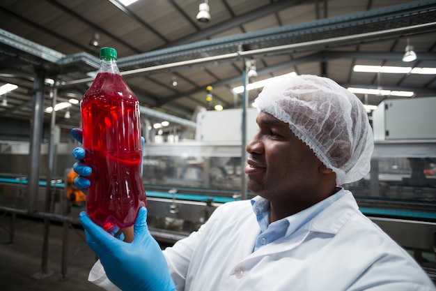 Photo factory engineer holding a bottle of juice