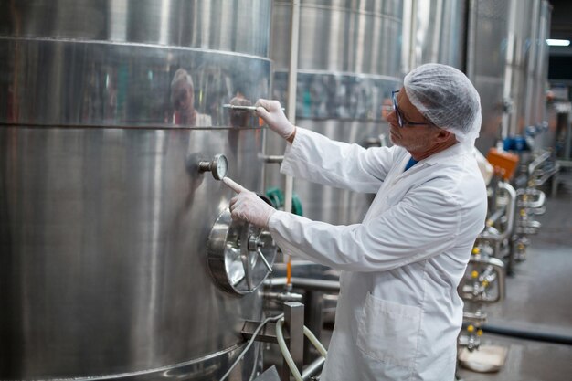 Factory engineer monitoring a pressure gauge of storage tank