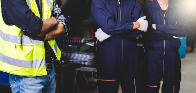 Photo the factory engineer standing and crossed arm to show confidence between working inside the factory. industrial workman working in the factory.