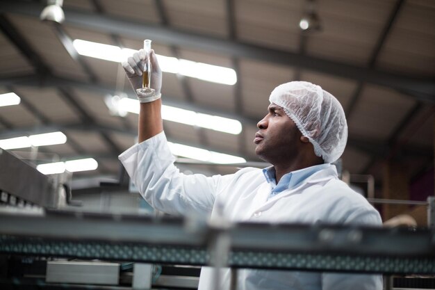 Factory engineers checking a sample of drink