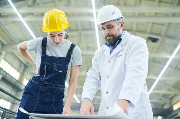 Ingegneri di fabbrica che discutono i piani