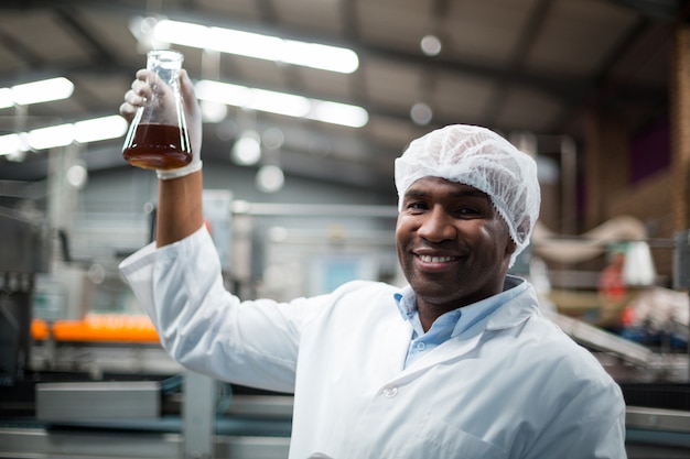 Factory engineers holding a sample of drink