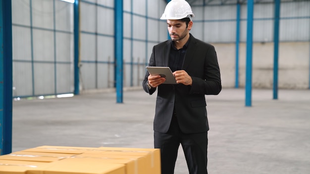 Direttore di fabbrica utilizzando computer tablet in magazzino o in fabbrica