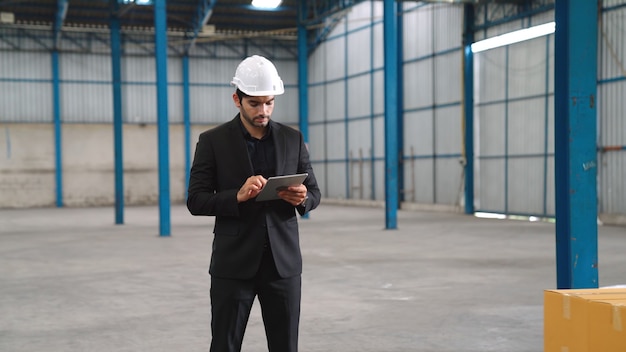 Factory manager using tablet computer in warehouse or factory 