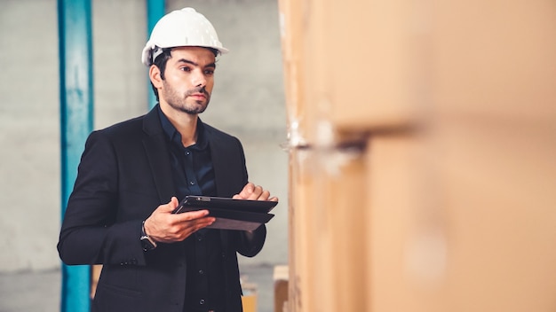 Factory manager using tablet computer in warehouse