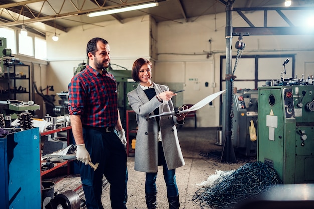 Factory supervisor talking with employee in manufacturing factory