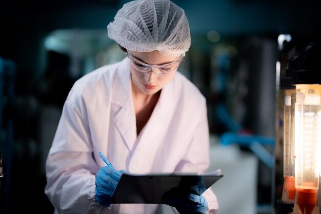 Foto lavoratore di fabbrica che controlla le bottiglie d'acqua nel magazzino della fabbrica industriale