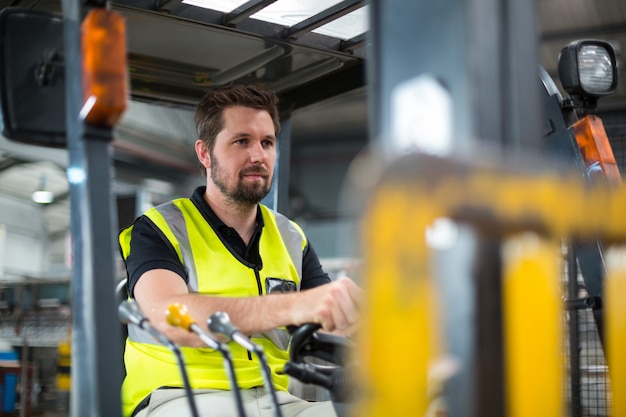 Factory worker driving forklift