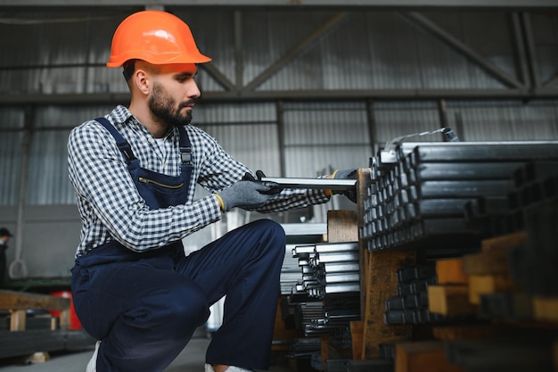 Factory worker measures the metal profile