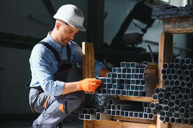 Factory worker measures the metal profile