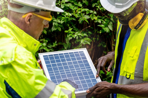 持続可能な技術のために太陽電池パネルをチェックする工場労働者の技術者エンジニアの男性