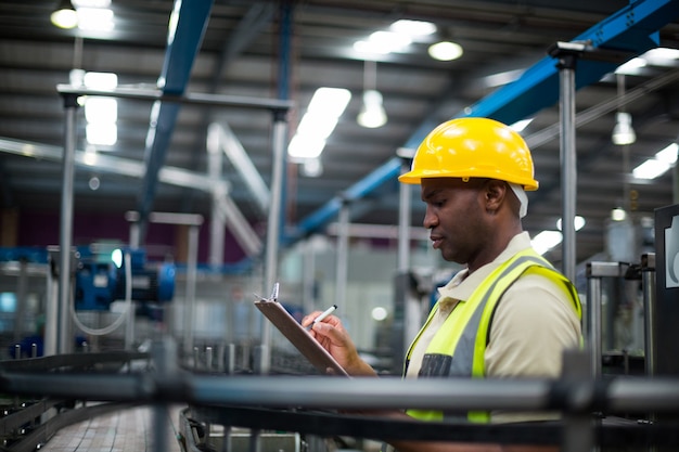 Factory worker writing on the clipboard