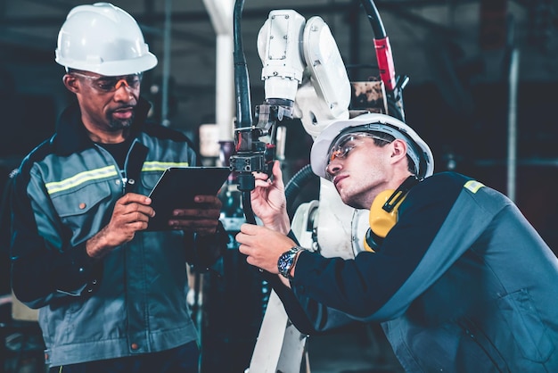 Factory workers working with adept robotic arm in a workshop