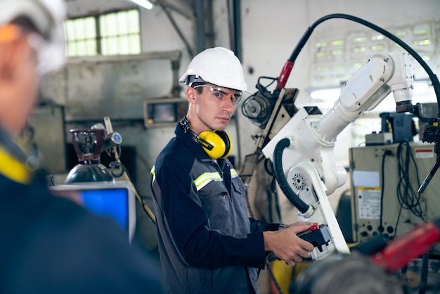 Factory workers working with adept robotic arm in a workshop