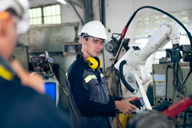 Factory workers working with adept robotic arm in a workshop