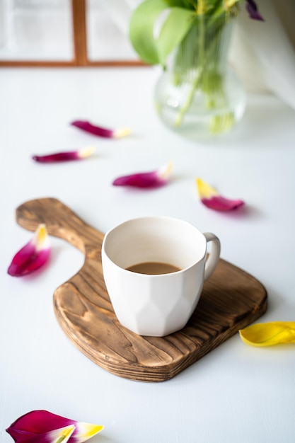 Un bouquet di tulipani sbiadito e resti di caffè sul tavolo alla fine
