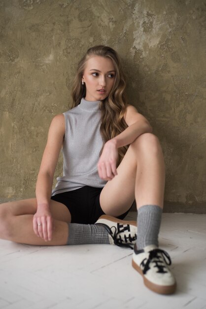 Photo fahion woman posing near grey wall