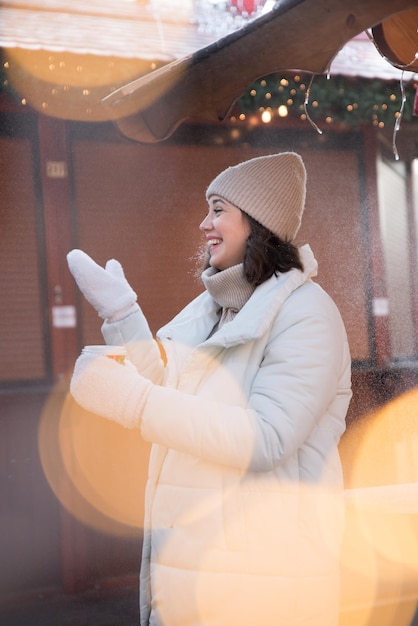 Fair girl dressed in a white jacket and a white hat the girl smiles cup of coffee in hand wooden summer house girl rejoices emotions