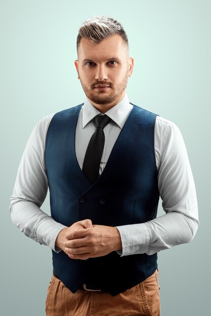 A fairhaired bearded man in a vest and tie