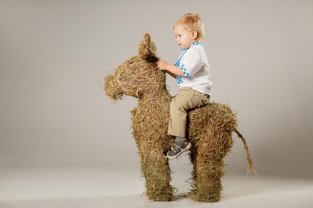 a fairhaired child feeds a calf from straw straw calf concept for an agricultural farm