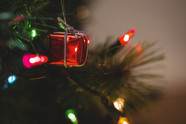 Fairy light and small gift box hanging on christmas tree